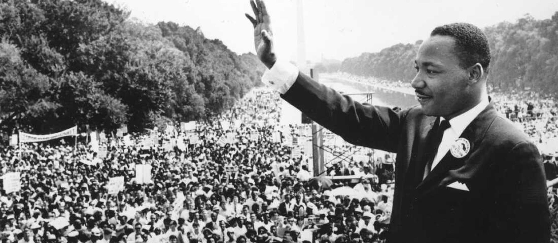 Martin Luther King Jr waves at a crowd