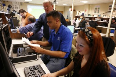 QCC Professor demonstrates hardware to students in lab