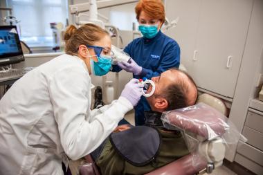 QCC student and professor work on patient in dental clinic