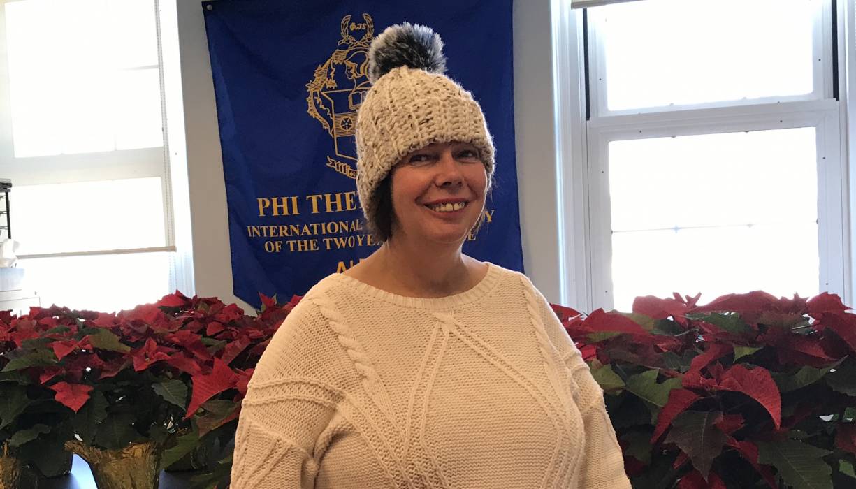 PTK Advisor Bonnie Coleman is surrounded by poinsettas PTK is selling to raise funds for the new Live and Learn Greenhouse. 