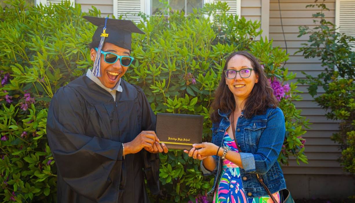 Gateway graduate receives his diploma from Gateway to College Resource Specialist, Jenna Glazer.