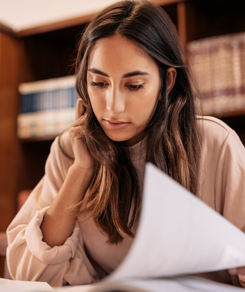 A woman looks at a piece of paper in a classroom