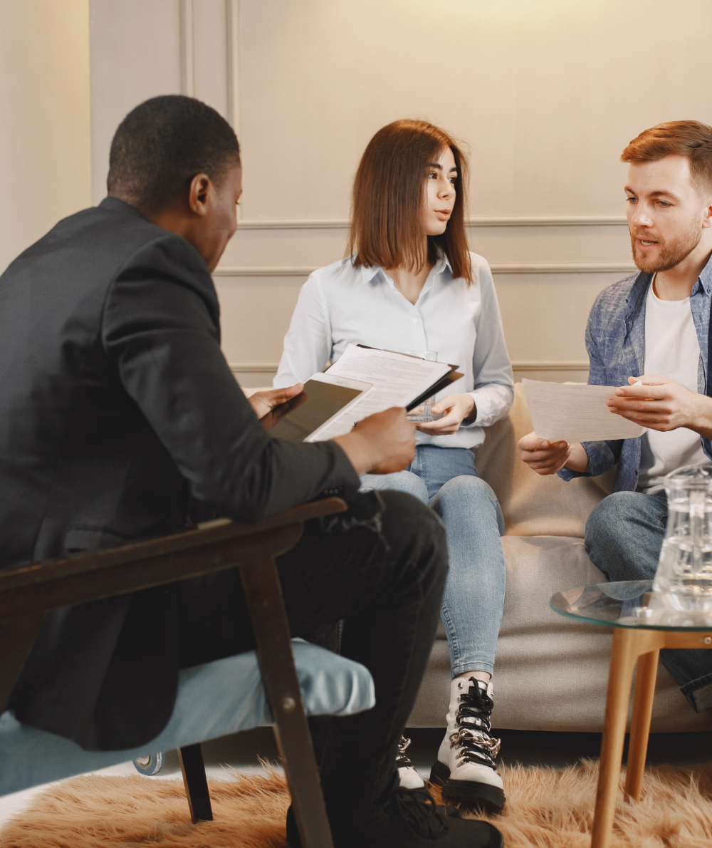 Two students discuss a document with a counselor