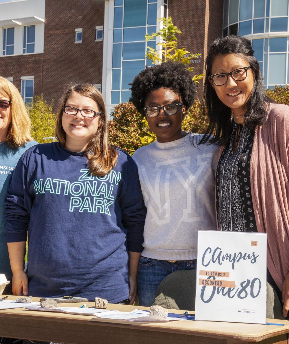 A group of students man a booth at a student club fair