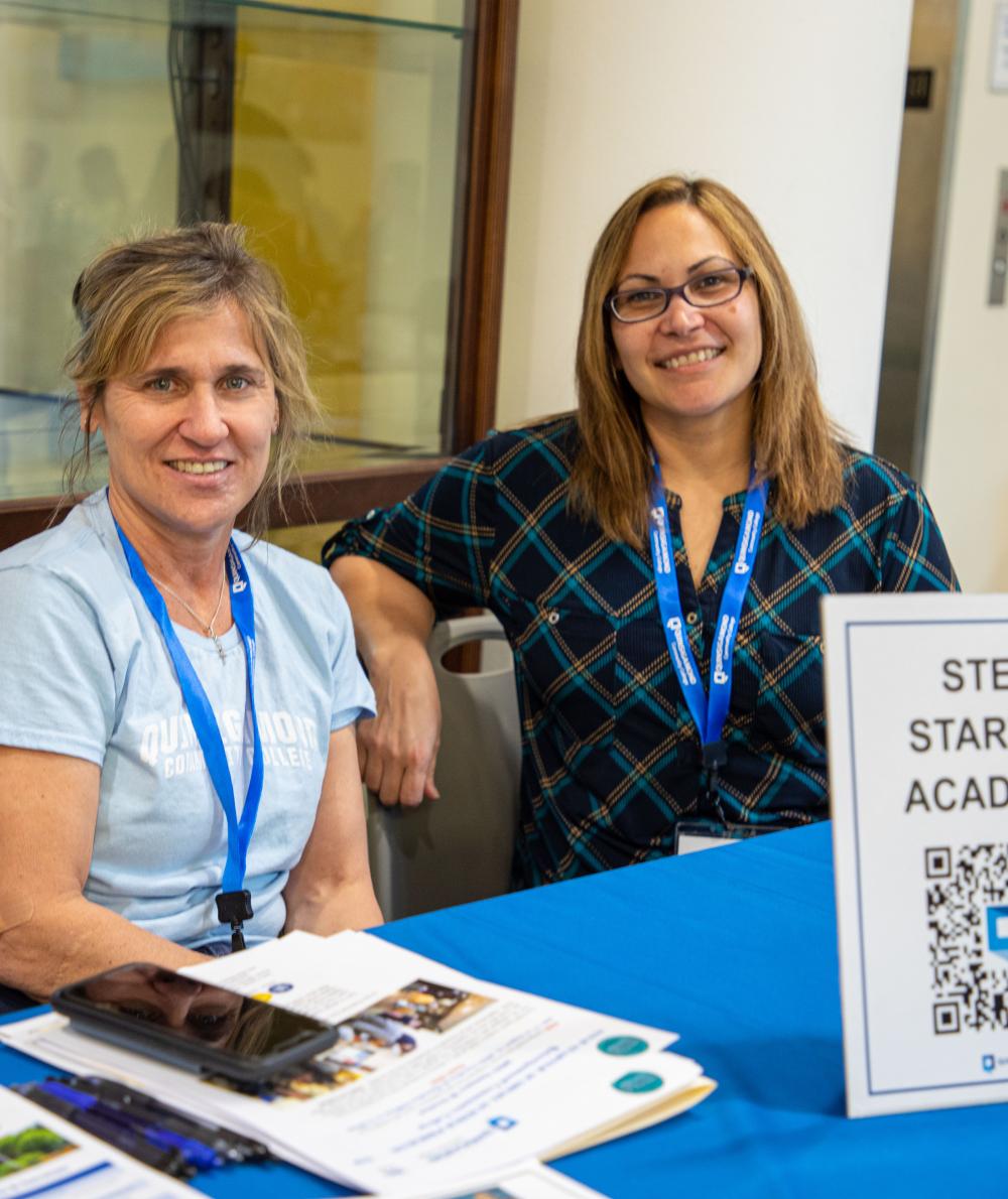 STEM staff man a booth to help students learn about the STEM Starter Academy