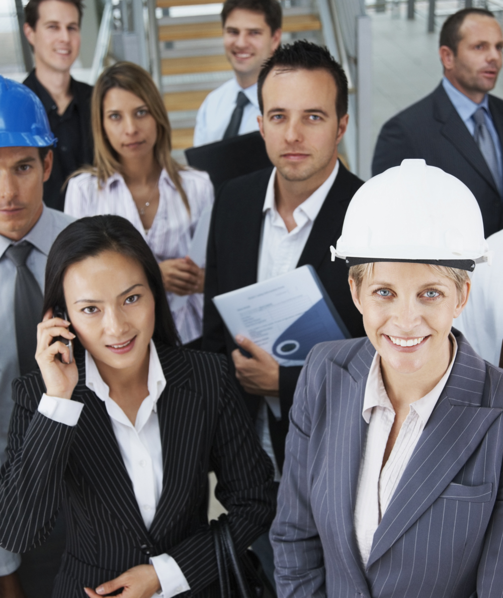 Professionals from many blue collar jobs in various attire pose for the camera in an office setting