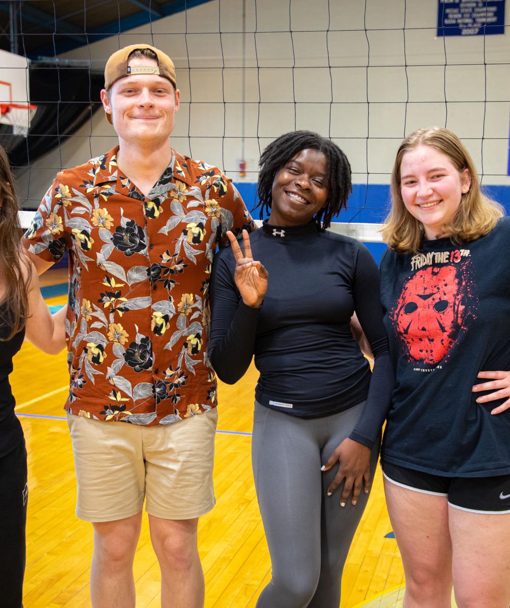 A group of intramural volleyball players pose together in the QCC Gym 