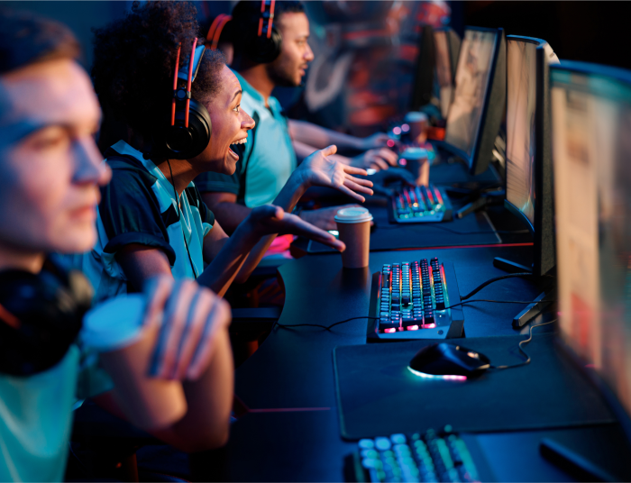 A bunch of male and female gamers look at their screens in a computer lab