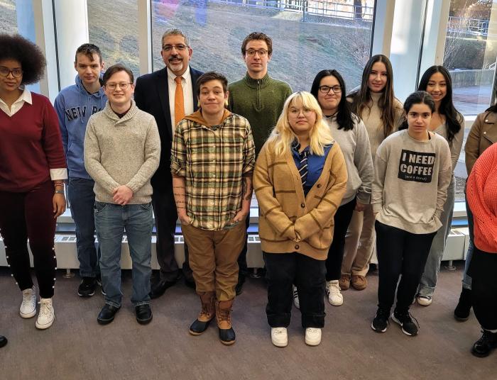 A group of STEM students pose with the president in the QuEST Center