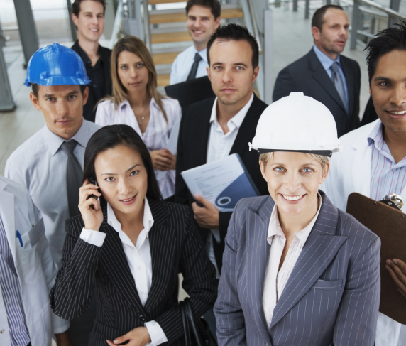 Professionals from many blue collar jobs in various attire pose for the camera in an office setting