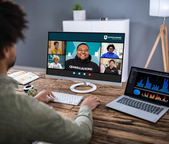 A student takes a remote class through Zoom on his laptop