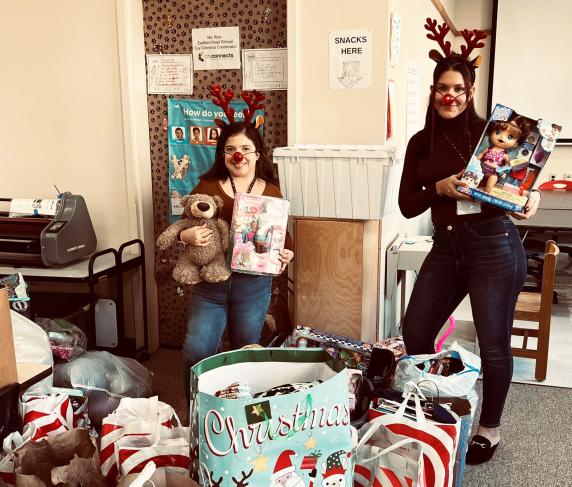 From left: Southbridge Elementary School liaisons Karina Alvarado and Selena Robles with donations from QCC's Human Services Clu