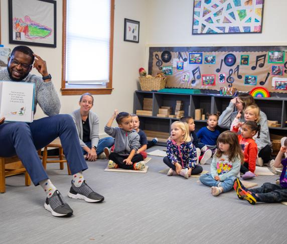 Executive Director of Diversity, Equity & Inclusion Kevin Lovaincy reads to children.