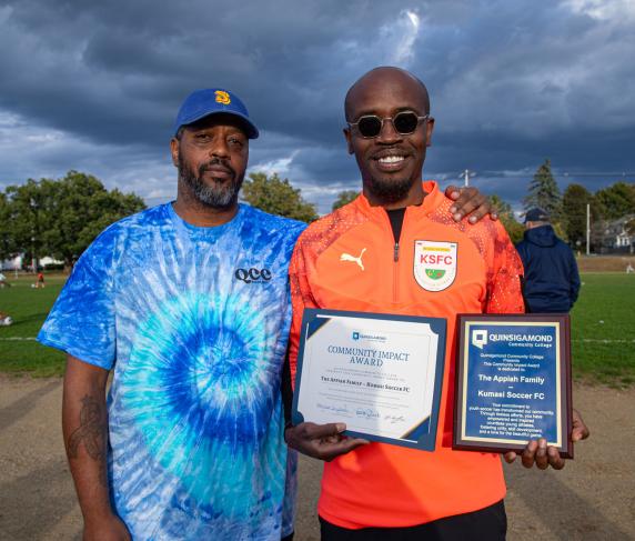 QCC Director of Community Engagement Sean Harris (left) and Kwame Appiah of Kumasi FC Soccer Club