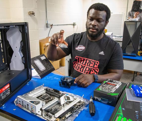 A qcc student taking apart a computer