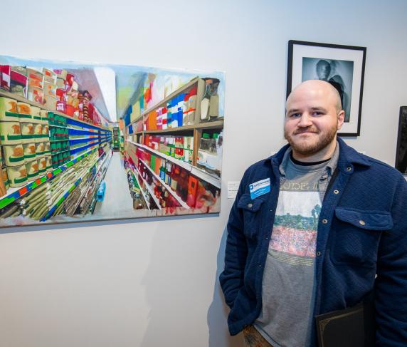 Carlos Crespo with his painting "Silver, Sword, and Stone". Photo by Nathan Fiske.