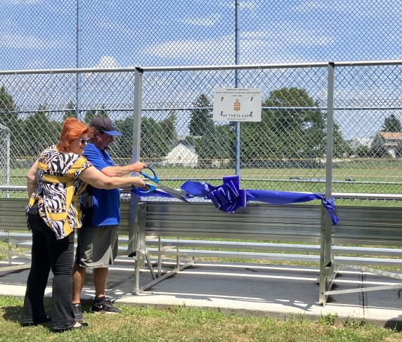 Former PTK President Kimberly Lindsey and Men's Baseball Coach Corey Coleman at the ribbon cutting for the new bleachers donated by PTK.