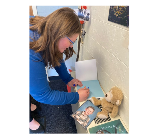 Enrollment Counselor Caitlin Bogue signs a copy of her book "Everett's Washing Machine" for the Children's School