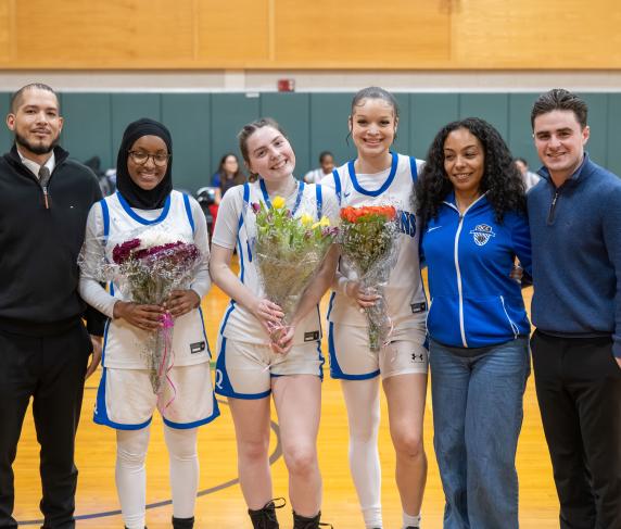 Sophomore night celebrated players (from left) Hawa Amdou, Maeve Nelson, and Morgan Jarret with coaching staff.
