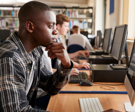 A male student registers for classes virtually in a computer lab