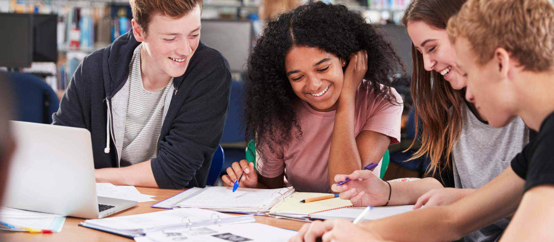 A group of students studies an assignment on a paper