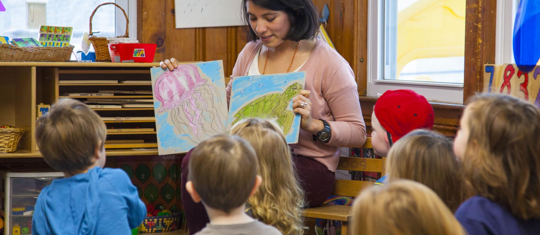 A QCC Early Childhood Education Student reads to a group of young children in the Children’s Lab