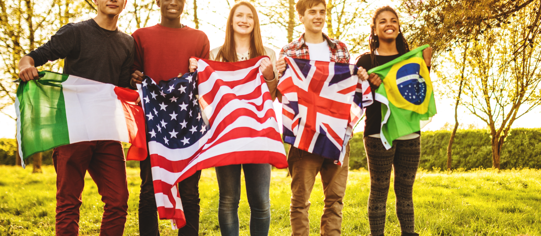 A group of students hold up flags from various countries