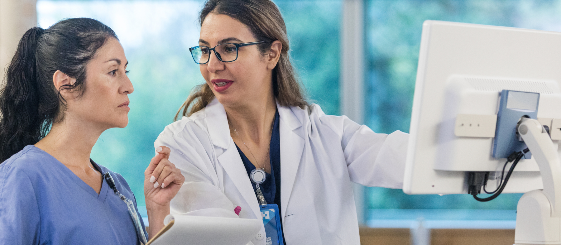 A lab tech shows another woman data from a screen