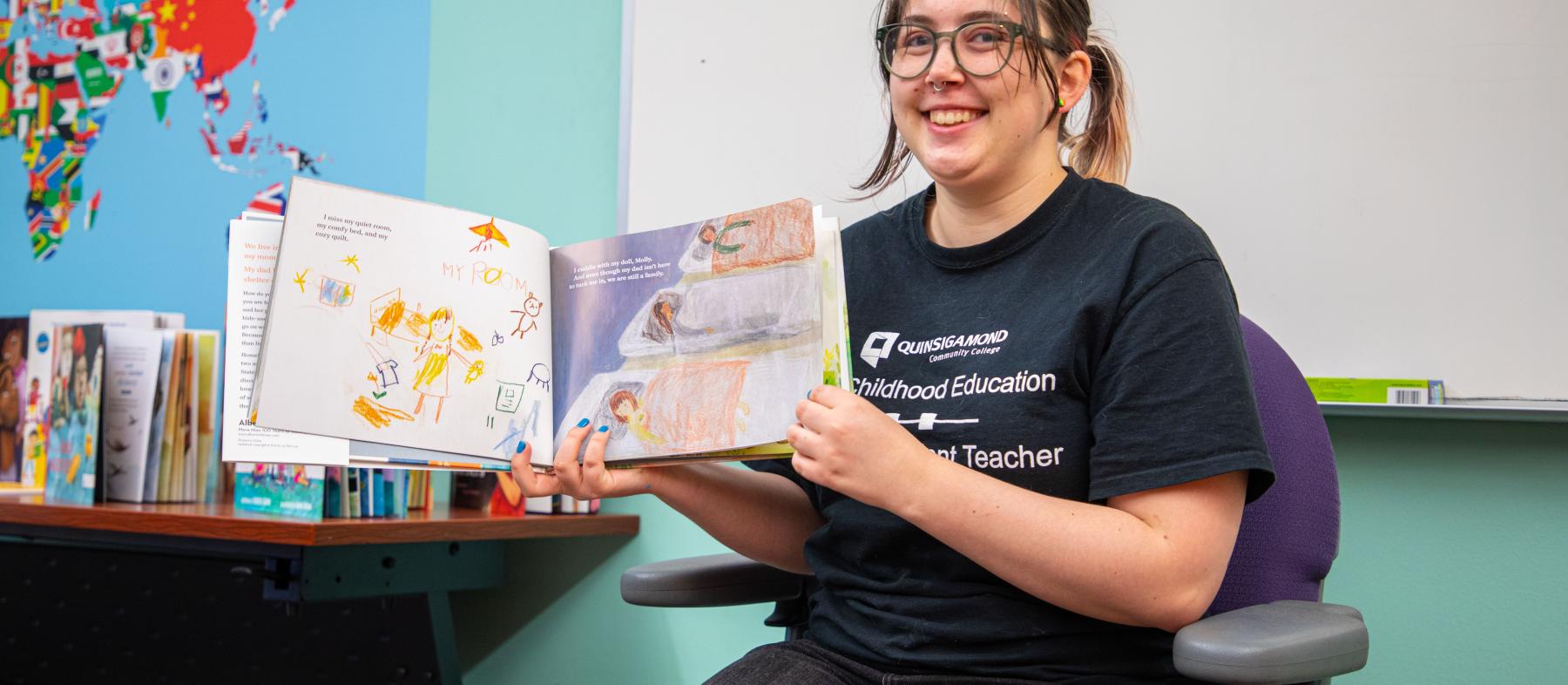 A QCC student reads a book to the class