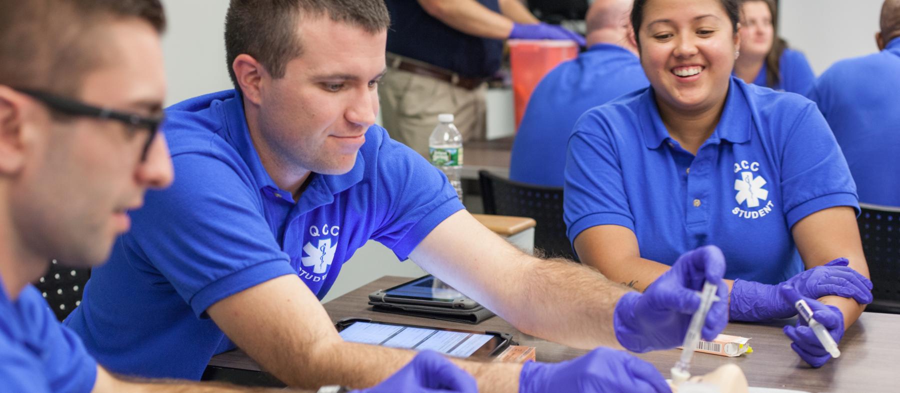 Students perform medical techniques in an EMT lab