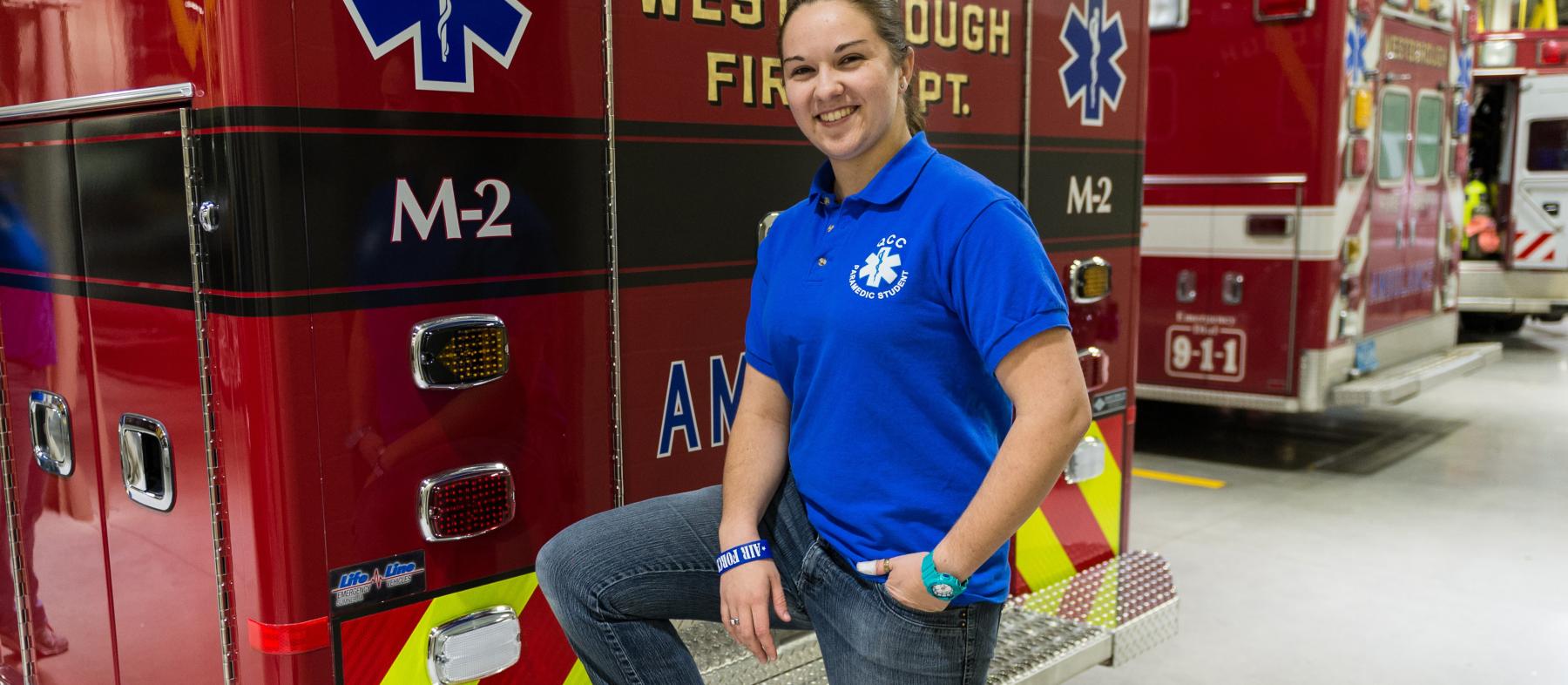 A female fire science graduate poses with a fire truck