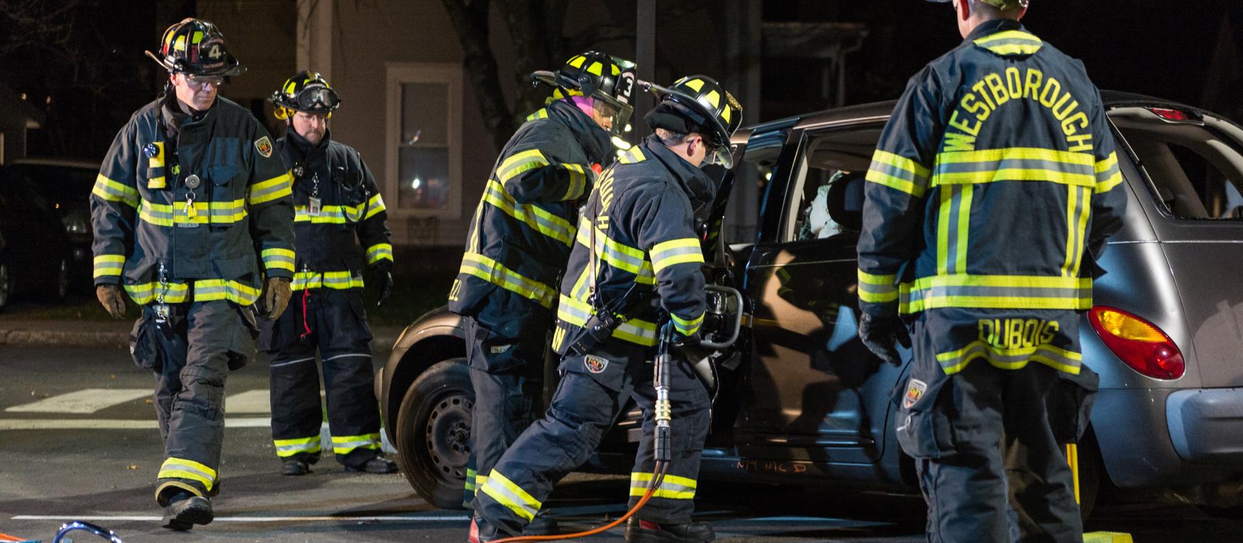 Firefighters work on a crashed car