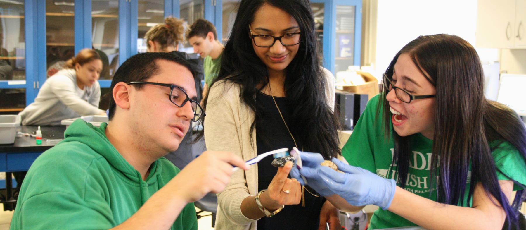 Students and professor work on lab in classroom