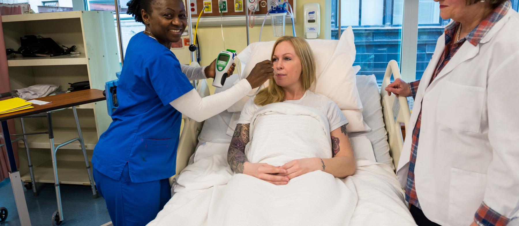 A nurse checks on a patient in a lab setup