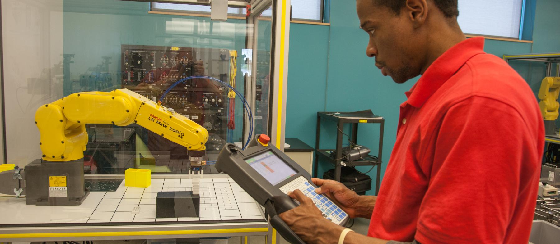 A student uses a robotic arm in the Advanced Manufacturing Lab