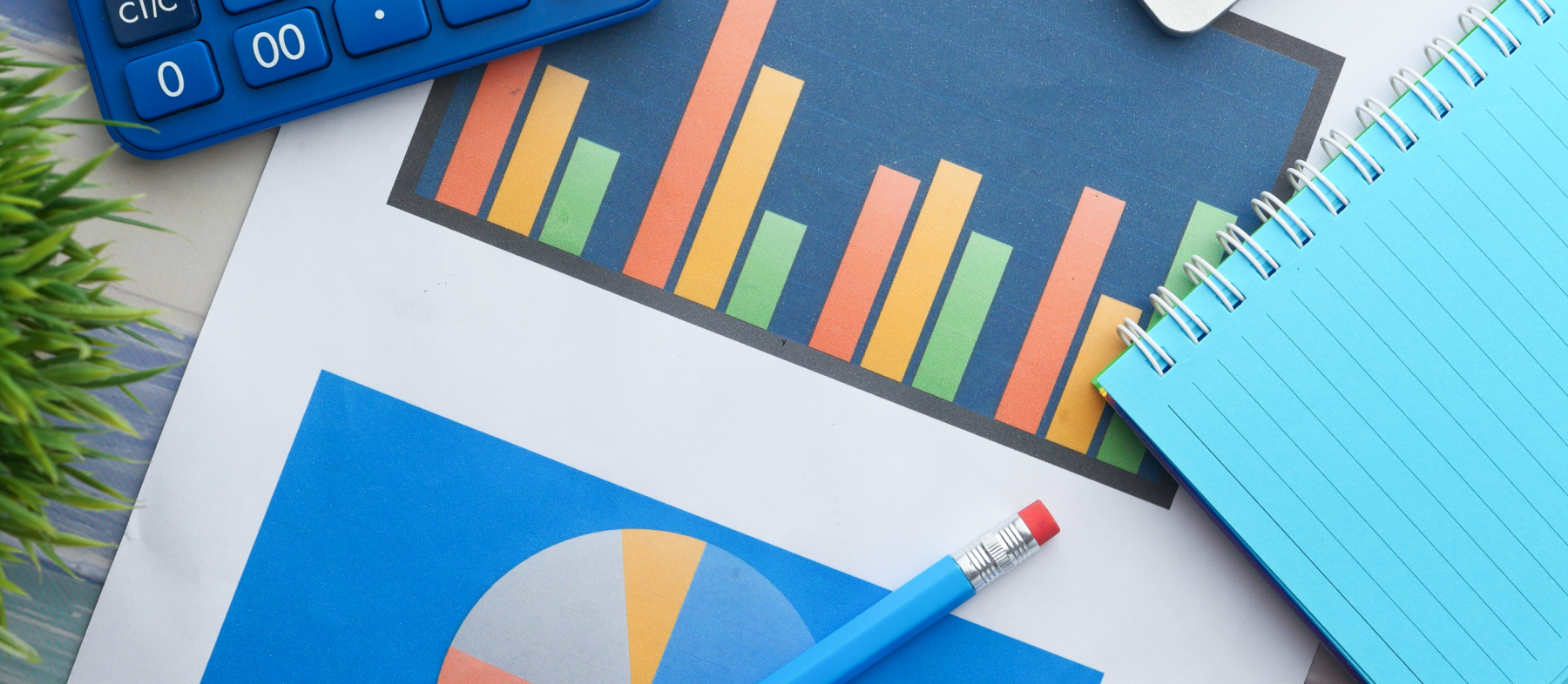 A desk with graphs, paper, and a calculator