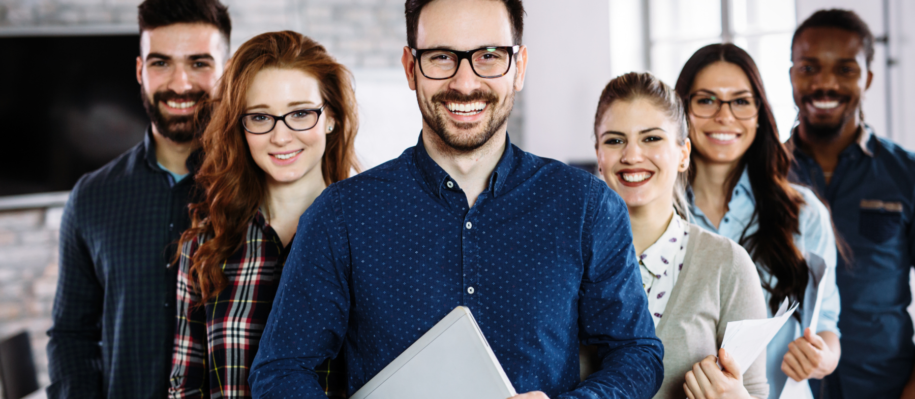 A group of professionals lines up in an office