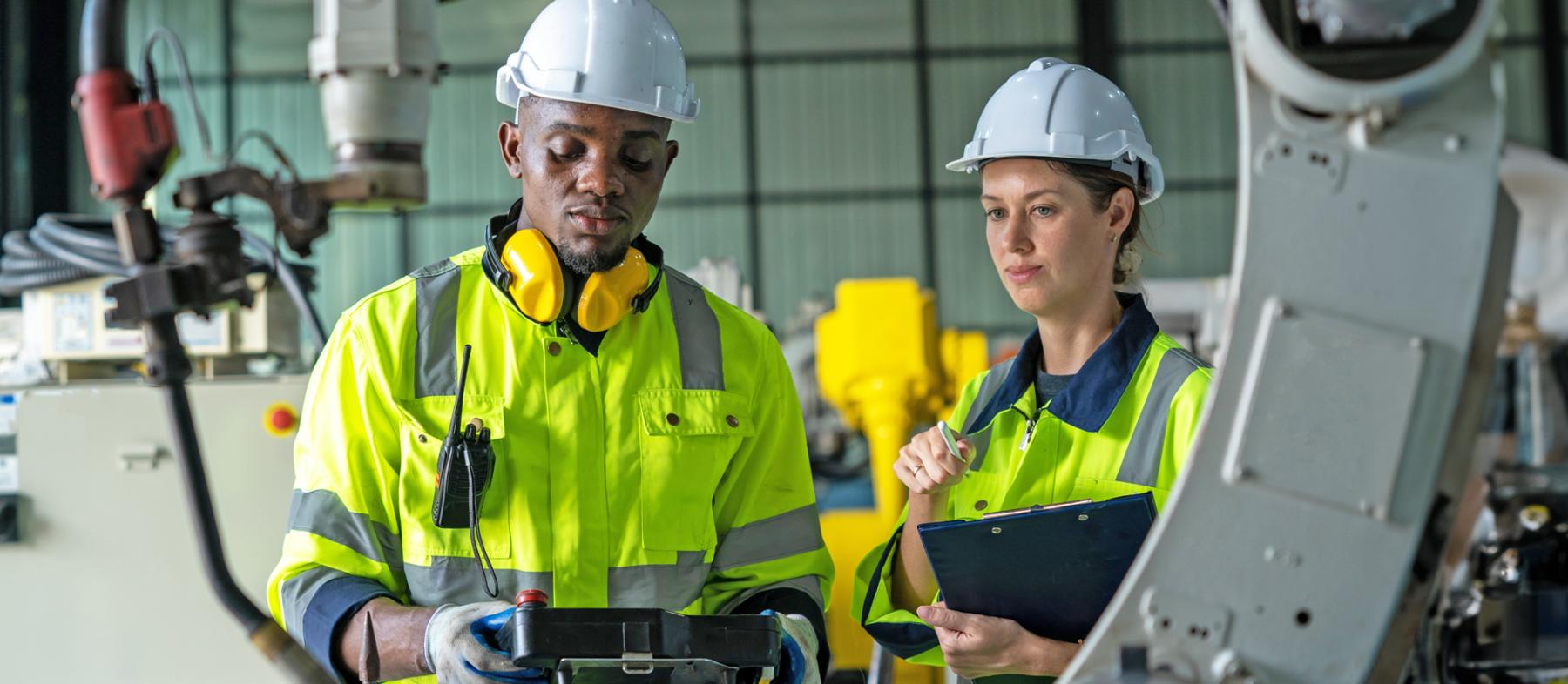 Two robotics technicians with robotic arm