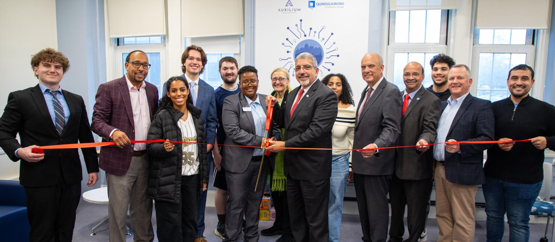 Dr. Pedraja and QCC employees cutting the ribbon in the Auxilium Center