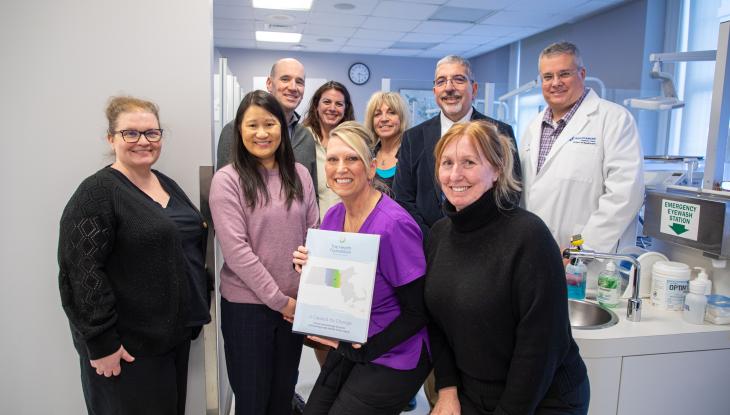 Front (from left): The Health Foundation Director of Finance and Administration Michelle L. Ewing, The Health Foundation President and CEO Amie Shei, Dental Clinic Operations & Facilities Mgr. Rene Cummings, and Prof. of Dental Assisting-Hygiene Jennifer McKeon. Back (from left) The Health Foundation Grants and Operations Manager Daniel P. Germain, Dir. of Grants Development Nicole Heldenbergh, Dental Hygiene Coordinator Jane Gauthier, QCC President Dr. Luis Pedraja, and Dean of Healthcare Pat Schmohl