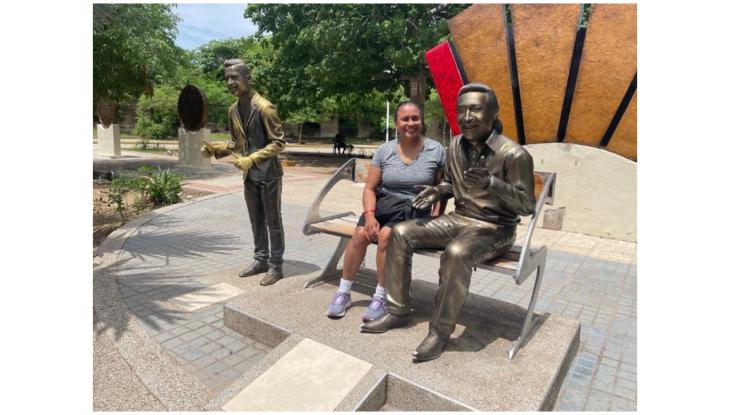Sandra Hinds in in Valledupar, Colombia with a sculpture of musician Rafael Calixto Escalona Martínez.