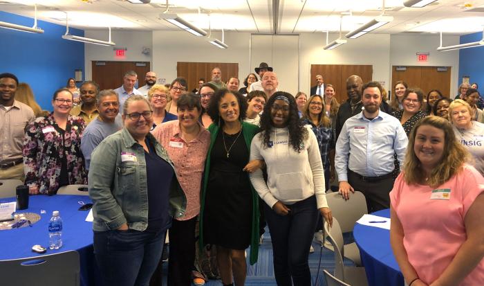 Maria Milagros (center in green) with QCC employees at the Staff Development Conference Maria Milagros (center in green) with QCC employees at the Staff Development Conference
