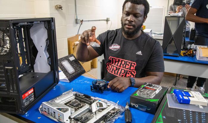 A qcc student taking apart a computer A qcc student taking apart a computer