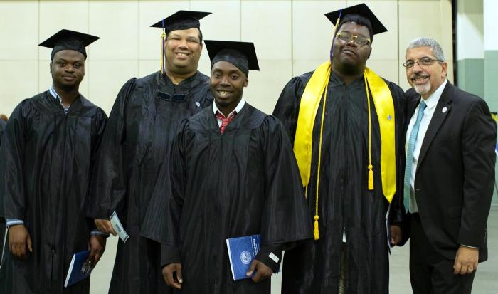 QCC President Dr. Luis Pedraja (right) with graduates QCC President Dr. Luis Pedraja (right) with graduates