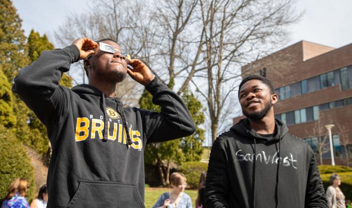 Students watch the eclipse through special glasses given at QCC's viewing event. Students watch the eclipse through special glasses given at QCC's viewing event.
