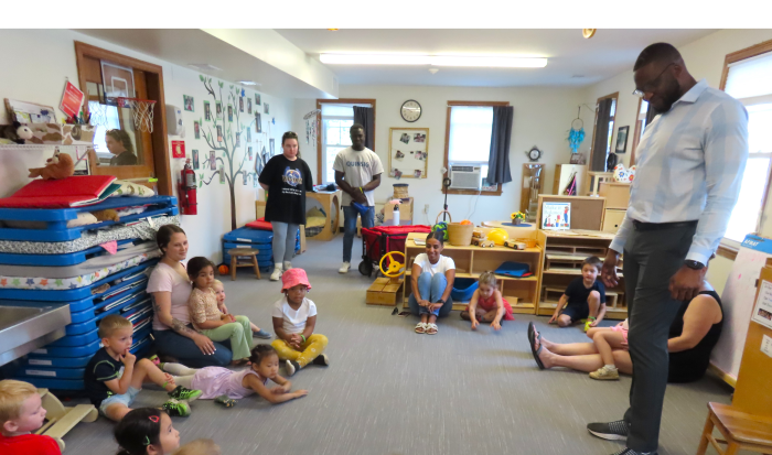 Executive Director of DEI Kevin Lovaincy greets children at the Children's School