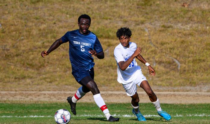 QCC's Arop Majak takes on a York County Community College player. QCC's Arop Majak takes on a York County Community College player.