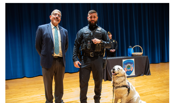QCC President Dr. Luis Pedraja (left) and Community Resource Officer Nick Yacuzzi with Siggy sporting his new badge QCC President Dr. Luis Pedraja (left) and Community Resource Officer Nick Yacuzzi with Siggy sporting his new badge
