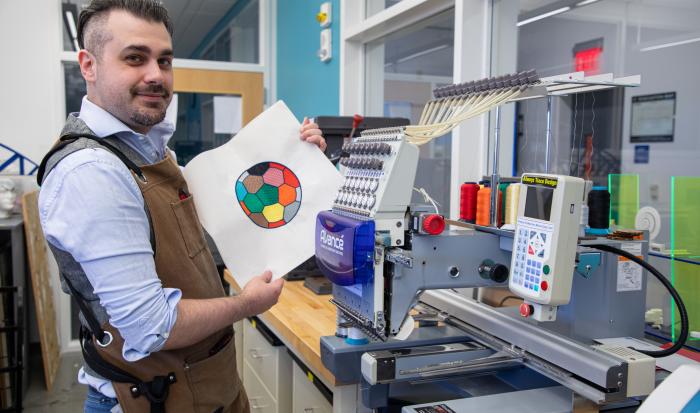 Coordinator of Engineering & Engineering Technology Laboratories R. Webster shows off a project from the embroidery machine. Coordinator of Engineering & Engineering Technology Laboratories R. Webster shows off a project from the embroidery machine.