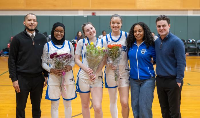 Sophomore night celebrated players (from left) Hawa Amdou, Maeve Nelson, and Morgan Jarrett, accompanied by (from left) Head Coach Johnny Diaz, Assistant Coach Marieshibell Pires, and Assistant Coach Neil McCarthy.